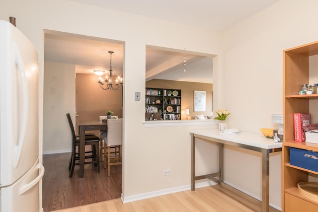 dining space featuring light wood-style flooring and a chandelier