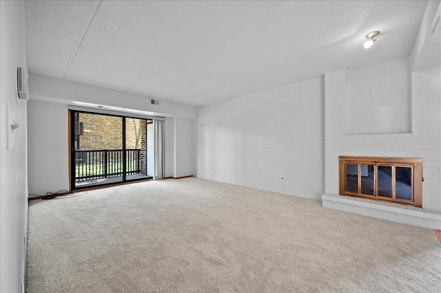 1502 Woodbridge Rd Unit 1D, Joliet, IL 60436 - unfurnished living room with carpet floors, a textured ceiling, and a brick fireplace