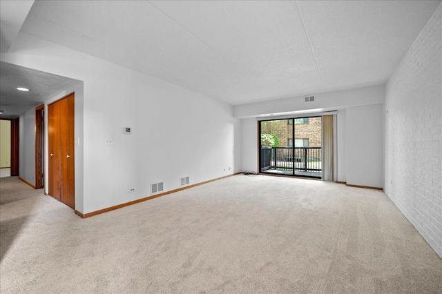 1502 Woodbridge Rd Unit 1D, Joliet, IL 60436 - carpeted spare room featuring baseboards, brick wall, and a textured ceiling