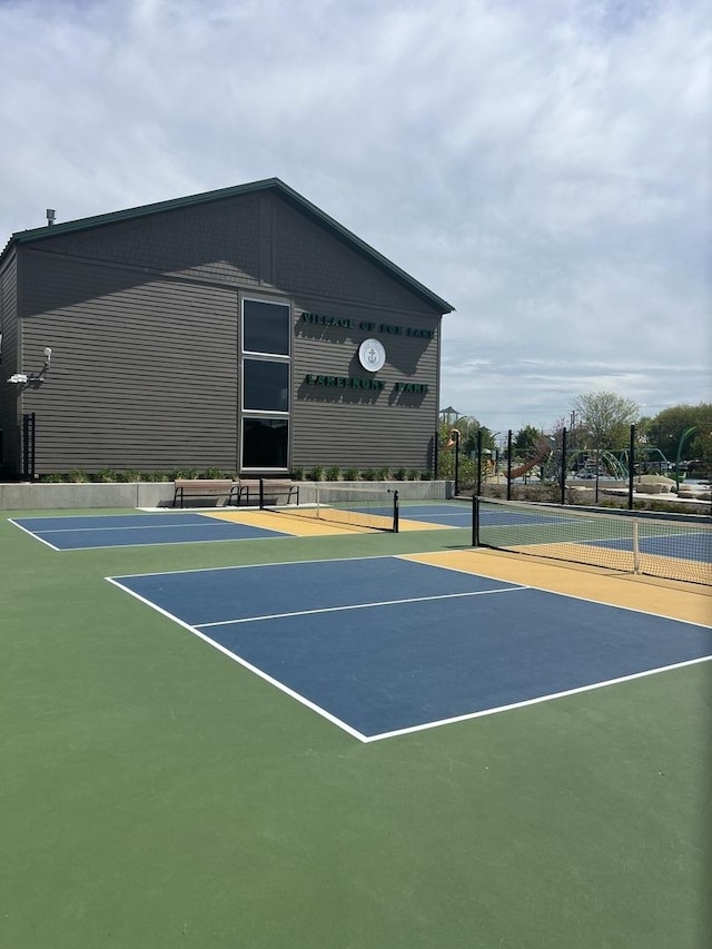view of tennis court with community basketball court and fence