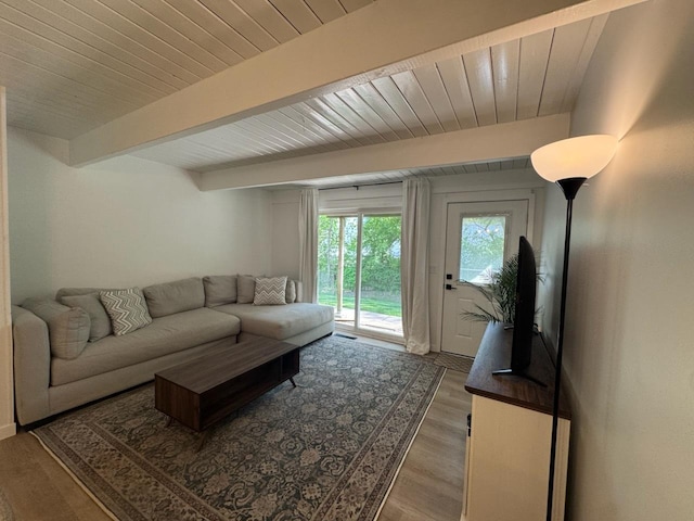 living area featuring wood finished floors, beam ceiling, and wooden ceiling