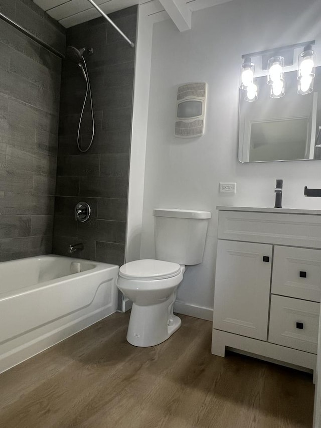full bath with wood finished floors, toilet, washtub / shower combination, vanity, and baseboards