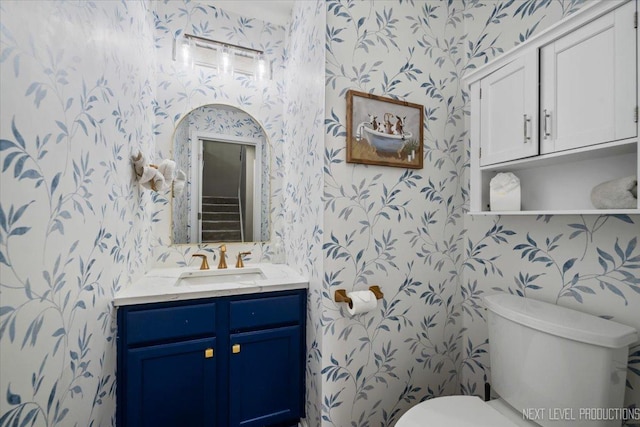 bathroom featuring wallpapered walls, toilet, and vanity