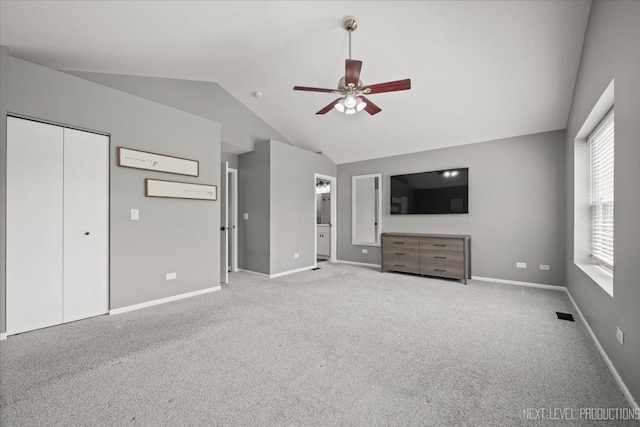 unfurnished bedroom with lofted ceiling, carpet, baseboards, ensuite bath, and ceiling fan