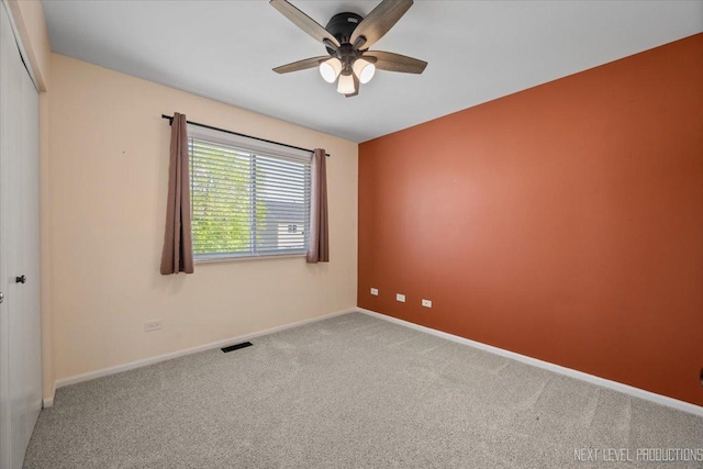 empty room with ceiling fan, carpet floors, and baseboards