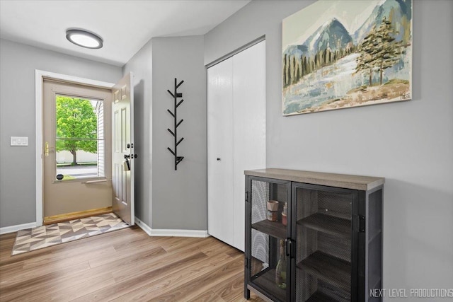 entryway with wood finished floors and baseboards