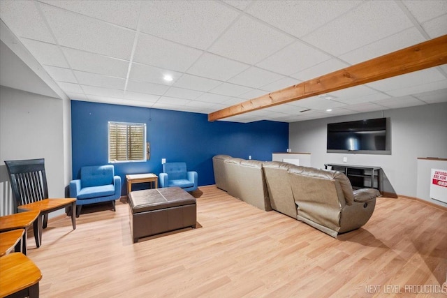 living room featuring wood finished floors, a paneled ceiling, and baseboards