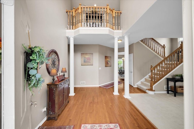 10905 Manhattan Dr, Huntley, IL 60142 - entryway with ornate columns, baseboards, wood finished floors, a towering ceiling, and stairs