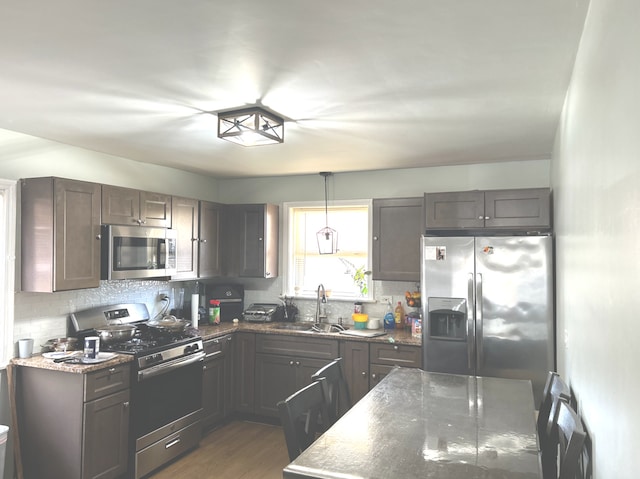 8020 S Mozart St, Chicago, IL 60652 - kitchen featuring stainless steel appliances, a sink, tasteful backsplash, dark stone counters, and wood finished floors