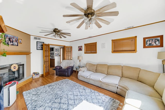1311 Harvey Ave, Berwyn, IL 60402 - living area with wood finished floors, a ceiling fan, ornamental molding, and a tiled fireplace
