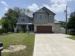 313 Roger Rd, Darien, IL 60561 - craftsman-style house featuring an attached garage, concrete driveway, a front yard, and stone siding