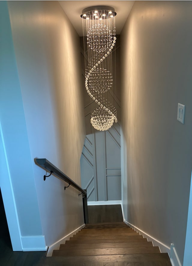 313 Roger Rd, Darien, IL 60561 - stairway with a chandelier, wood finished floors, and baseboards