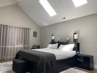 313 Roger Rd, Darien, IL 60561 - bedroom featuring a skylight, high vaulted ceiling, and baseboards