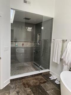 313 Roger Rd, Darien, IL 60561 - bathroom featuring a shower stall, baseboards, and a freestanding bath