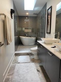 313 Roger Rd, Darien, IL 60561 - full bath featuring double vanity, a freestanding tub, baseboards, toilet, and a tile shower