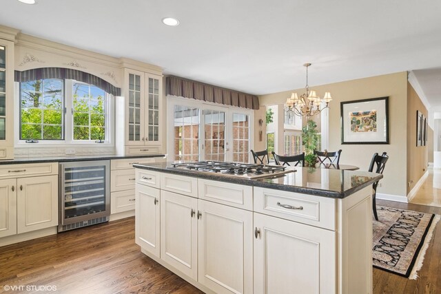 80 Gaelic Ct, Inverness, IL 60010 - kitchen featuring wine cooler, stainless steel gas stovetop, a chandelier, dark wood-style flooring, and glass insert cabinets