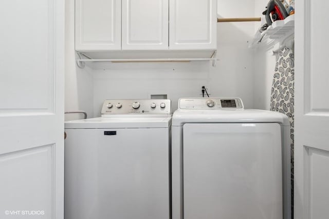 clothes washing area with washer and dryer and cabinet space