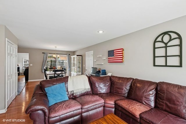 living room with wood finished floors, baseboards, a chandelier, and recessed lighting