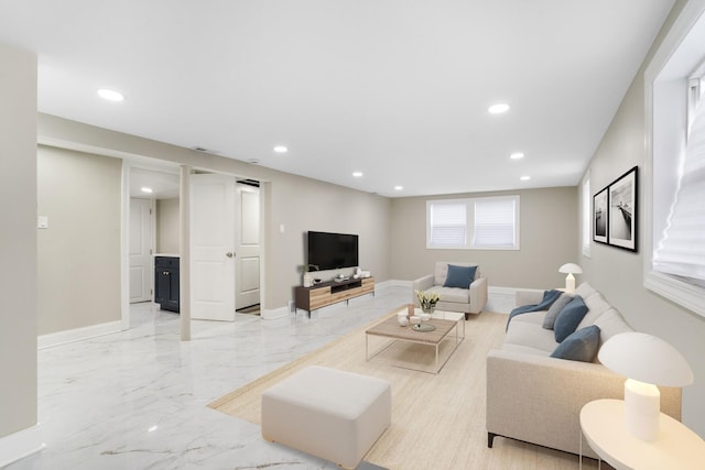 living area featuring recessed lighting, light marble finish floors, and baseboards