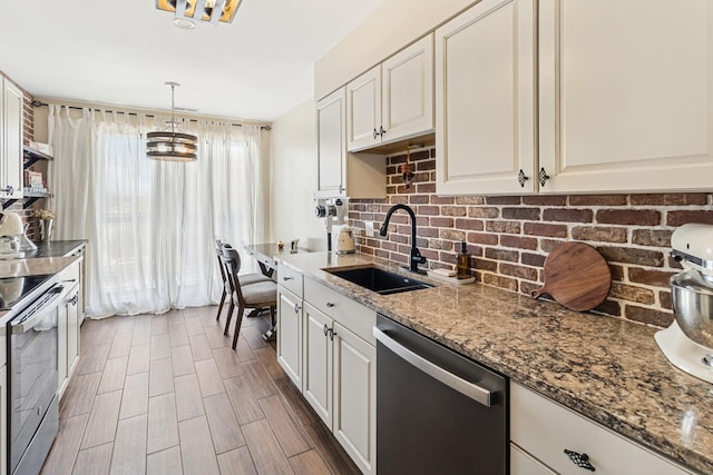 711 S River Rd Unit 503, Des Plaines, IL 60016 - kitchen featuring stainless steel appliances, a sink, backsplash, stone counters, and hanging light fixtures