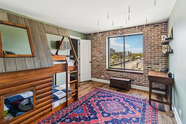 711 S River Rd Unit 503, Des Plaines, IL 60016 - sitting room featuring wood finished floors, brick wall, and baseboards