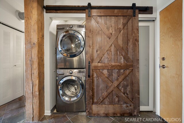 1735 W Diversey Pkwy Unit 416, Chicago, IL 60614 - laundry area featuring stacked washer / dryer, a barn door, and baseboards