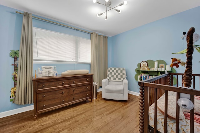 884 Arnold Ct, Des Plaines, IL 60016 - bedroom featuring wood finished floors, baseboards, and a crib