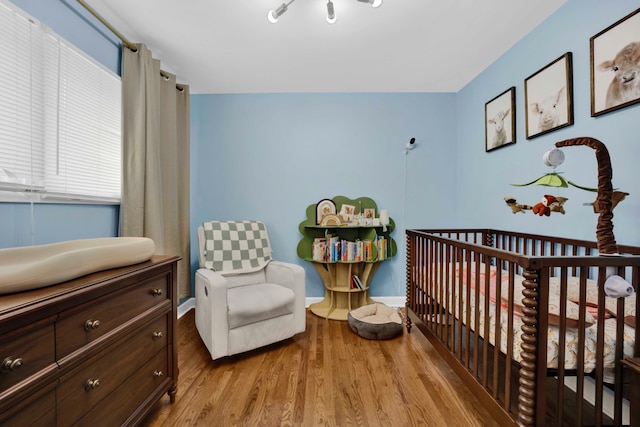 884 Arnold Ct, Des Plaines, IL 60016 - bedroom with wood finished floors, baseboards, and a nursery area