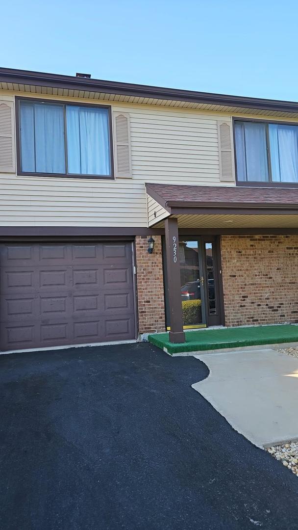9230 Hartwood Ct Unit 1404, Orland Park, IL 60462 - view of front of property with brick siding, an attached garage, and driveway