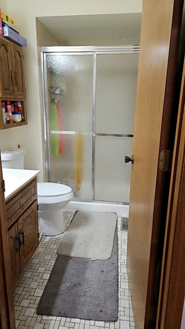 9230 Hartwood Ct Unit 1404, Orland Park, IL 60462 - bathroom with toilet, vanity, and a shower stall