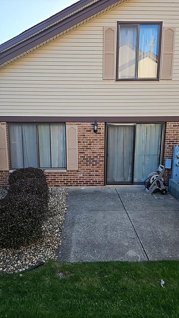 9230 Hartwood Ct Unit 1404, Orland Park, IL 60462 - view of side of property with brick siding and a patio