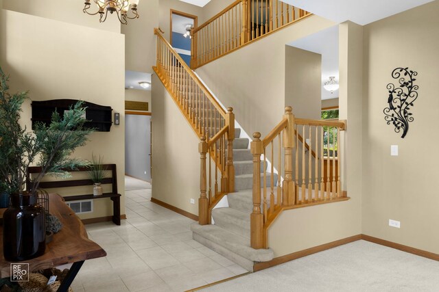 24001 W Walnut Cir, Plainfield, IL 60585 - stairs featuring a chandelier, a high ceiling, baseboards, and tile patterned flooring