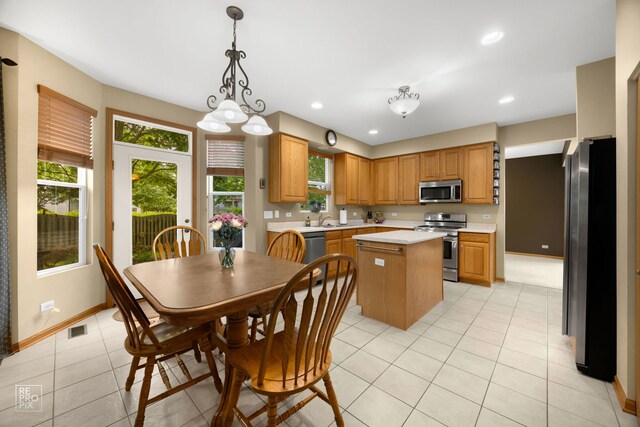 24001 W Walnut Cir, Plainfield, IL 60585 - kitchen featuring appliances with stainless steel finishes, light countertops, a center island, a sink, and baseboards