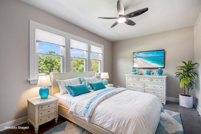 bedroom featuring baseboards, wood finished floors, and ceiling fan