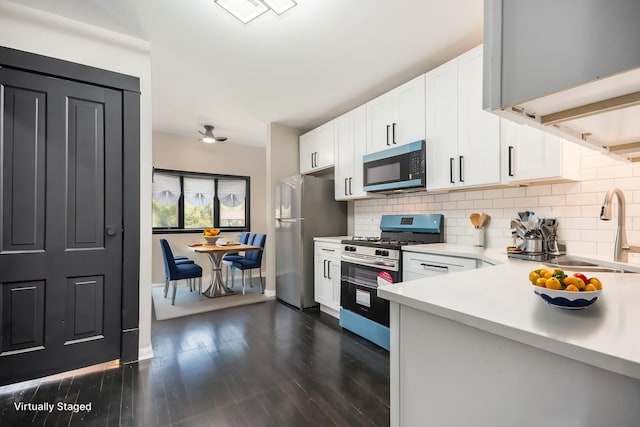 kitchen featuring appliances with stainless steel finishes, light countertops, tasteful backsplash, and white cabinetry
