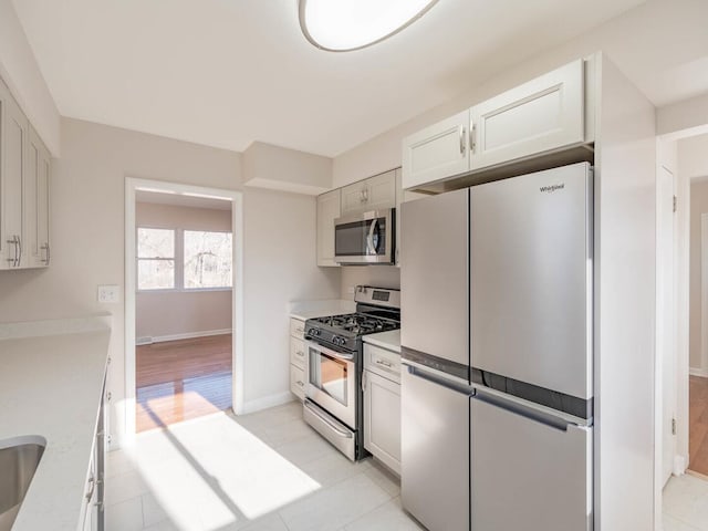 191 Juneway Ter, Lake Bluff, IL 60044 - kitchen featuring stainless steel appliances, baseboards, light countertops, and light tile patterned floors