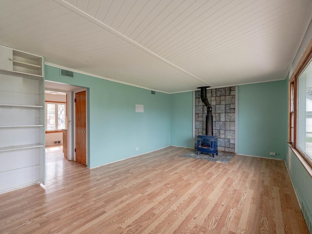 348 Behm Dr, Grayslake, IL 60030 - unfurnished living room featuring a wood stove, wood finished floors, ornamental molding, and healthy amount of natural light