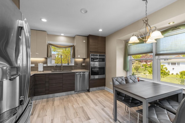 186 Sunrise Dr, Wheeling, IL 60090 - kitchen featuring appliances with stainless steel finishes, a sink, light countertops, modern cabinets, and tasteful backsplash