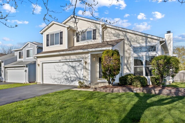 900 Taralon Trl, Lake In The Hills, IL 60156 - view of front of property featuring driveway, a front yard, an attached garage, and a chimney