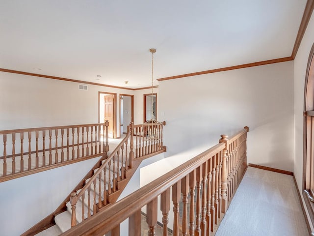 hallway featuring ornamental molding, carpet, an upstairs landing, and baseboards