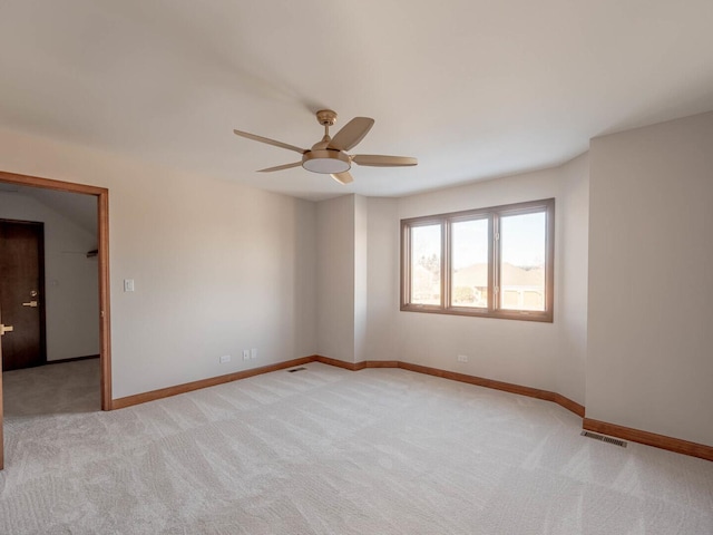 empty room with a ceiling fan, light carpet, and baseboards