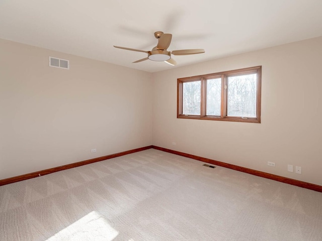 unfurnished room featuring ceiling fan, light carpet, and baseboards