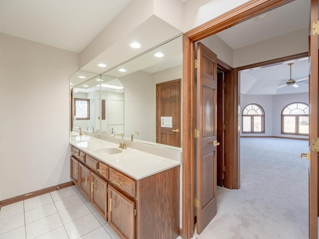 bathroom featuring ceiling fan, healthy amount of natural light, baseboards, recessed lighting, and double vanity