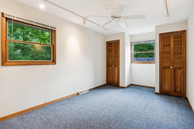 12811 S 82nd Ct, Palos Park, IL 60464 - unfurnished bedroom with rail lighting, carpet, multiple closets, and baseboards