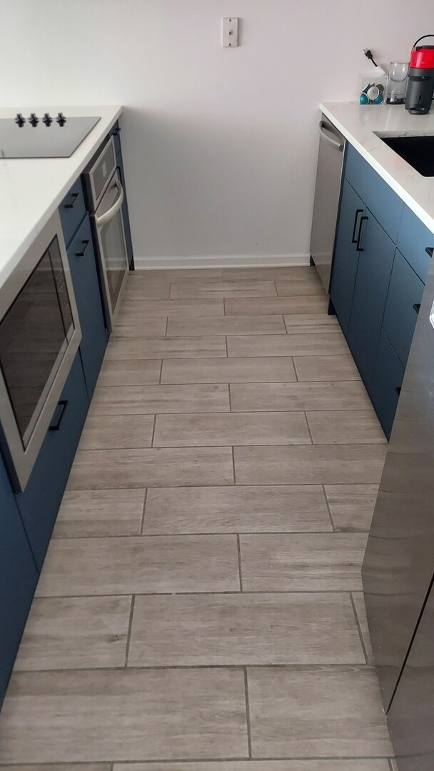 345 N La Salle Dr Unit 3305, Chicago, IL 60654 - kitchen view of stainless steel appliances, blue cabinets, wood finish floors, and baseboards