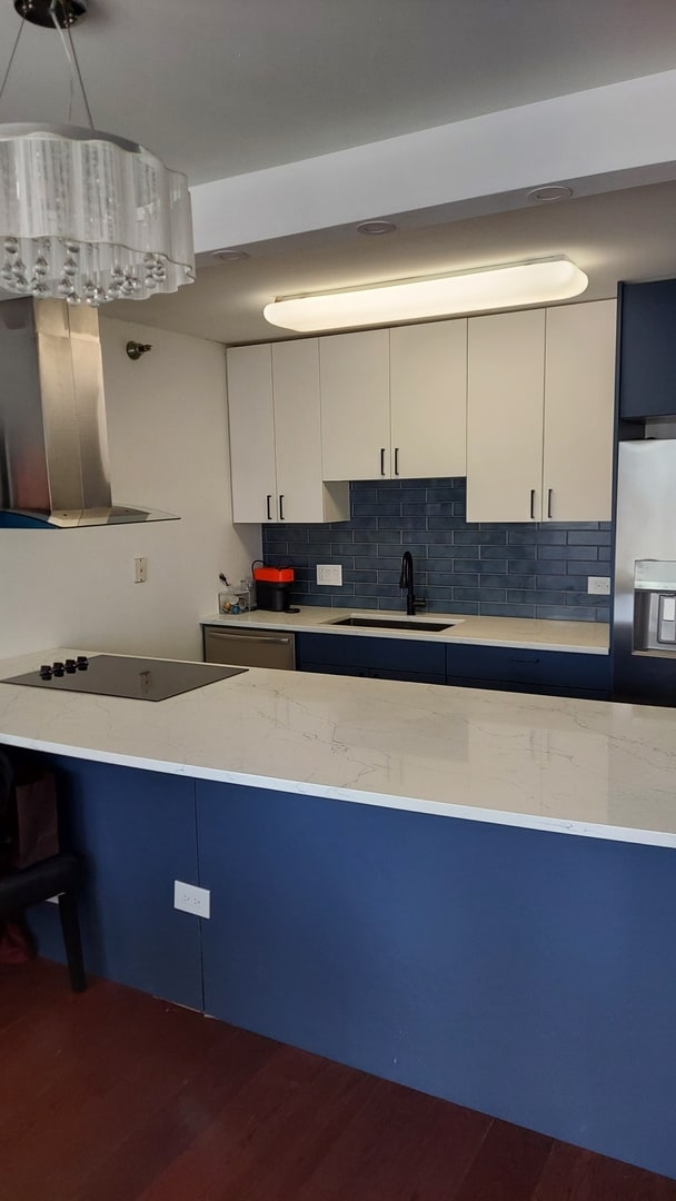 345 N La Salle Dr Unit 3305, Chicago, IL 60654 - kitchen with black electric stovetop, a sink, stainless steel fridge, tasteful backsplash, and dark wood-type flooring