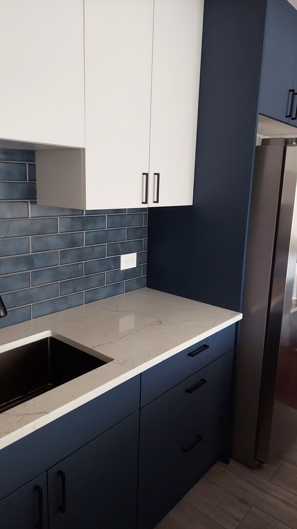 345 N La Salle Dr Unit 3305, Chicago, IL 60654 - kitchen featuring modern cabinets, freestanding refrigerator, light stone counters, a sink, and decorative backsplash