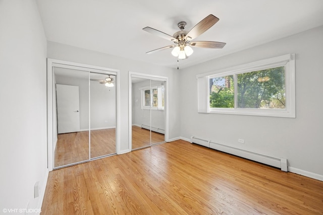 405 Wesley Ave Unit 6, Oak Park, IL 60302 - unfurnished bedroom featuring a baseboard heating unit, multiple closets, light wood-style flooring, and baseboards