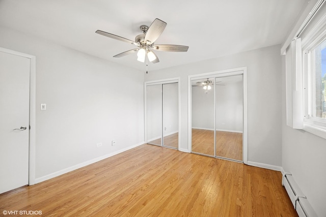405 Wesley Ave Unit 6, Oak Park, IL 60302 - unfurnished bedroom with baseboard heating, two closets, light wood-style floors, baseboards, and a ceiling fan