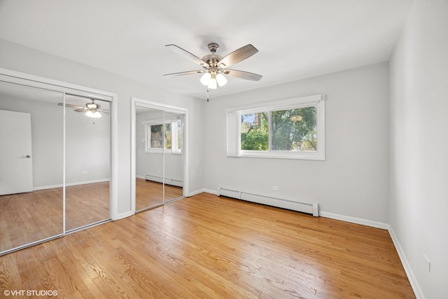 405 Wesley Ave Unit 6, Oak Park, IL 60302 - unfurnished bedroom featuring baseboard heating, multiple closets, wood finished floors, and baseboards